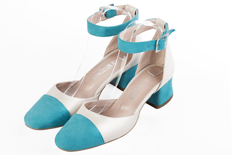 Turquoise blue and off white women's open side shoes, with a strap around the ankle. Round toe. Low flare heels. Front view - Florence KOOIJMAN